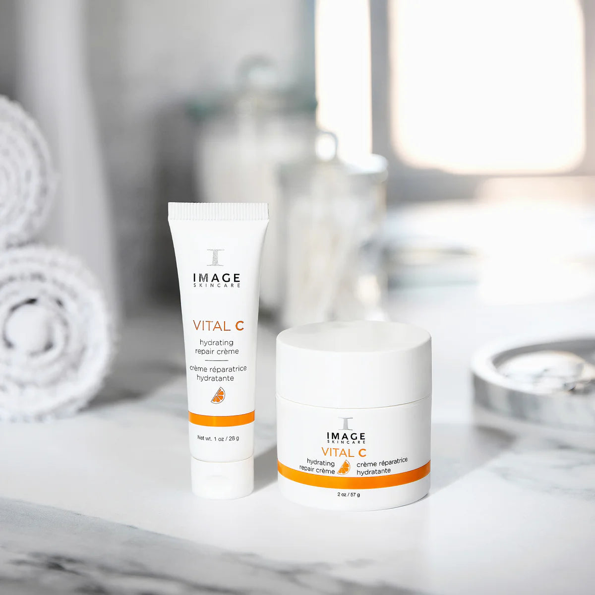 VITAL C Hydrating Repair Crème products on a marble counter with towels in the background.