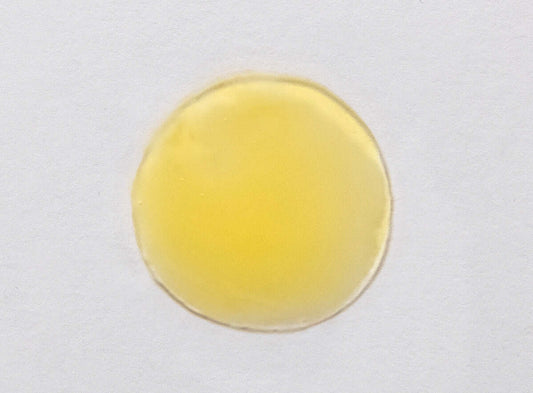 A drop of Vitamin C Green Tea Serum showing its smooth texture and encapsulated L-ascorbic acid for enhanced bioavailability and stability.