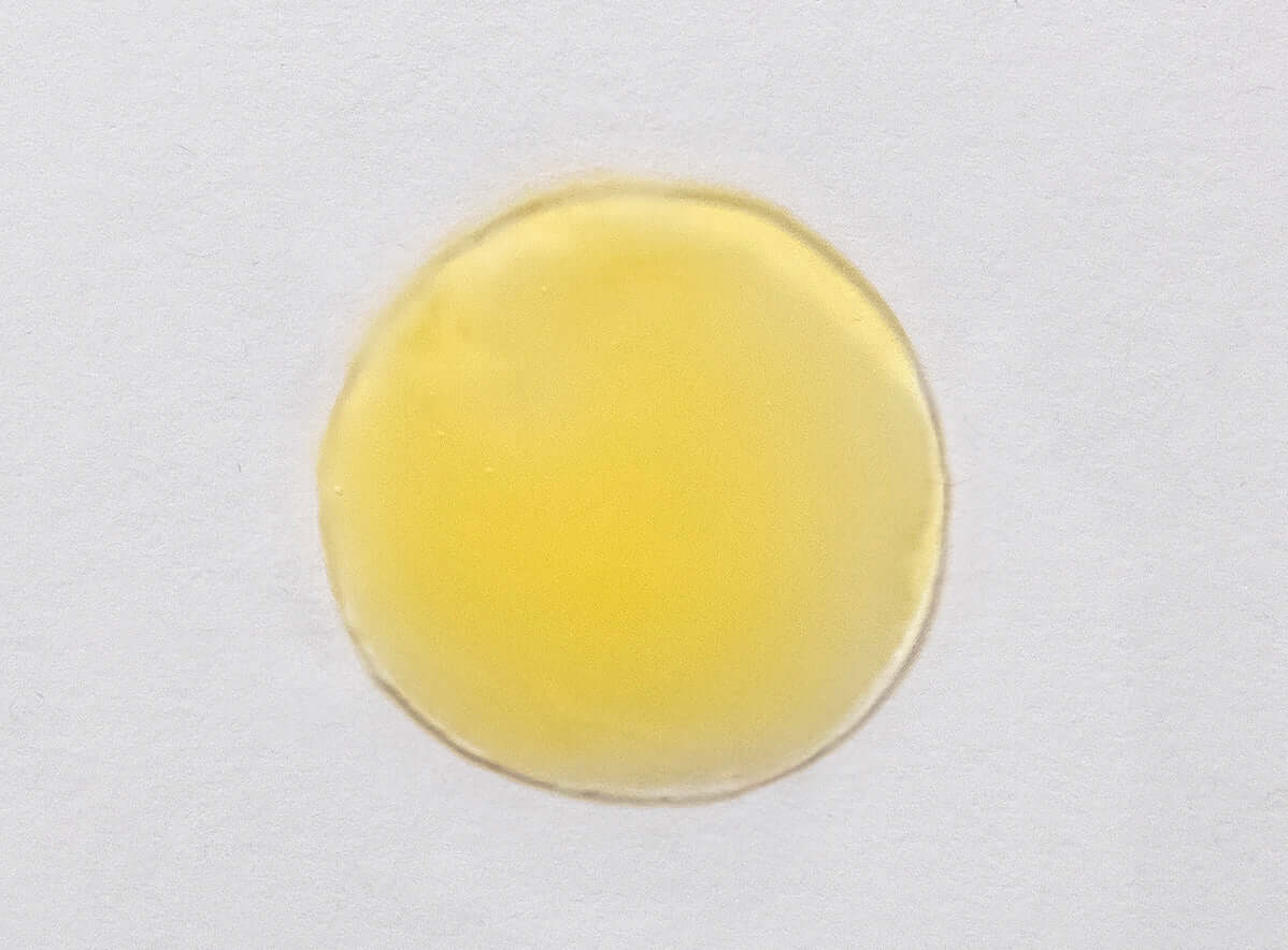 A drop of Triple C Serum showing its smooth texture and encapsulated L-ascorbic acid for enhanced bioavailability and stability.