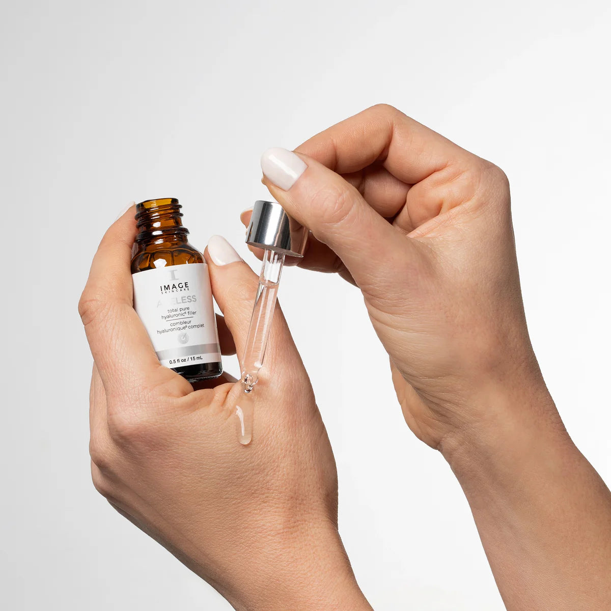 AGELESS Total Pure Hyaluronic 6 Filler being applied from dropper bottle for smoother skin.