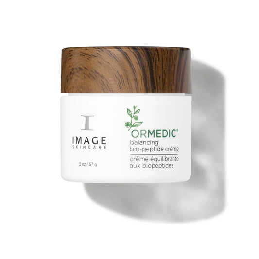 ORMEDIC® Balancing Biopeptide Crème in a jar with wood lid, nourishing skin for hydration and luminosity.