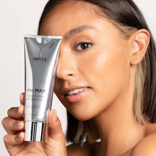 Image of The MAX™ Facial Cleanser held by a model, showcasing its luxurious packaging and creamy formula.