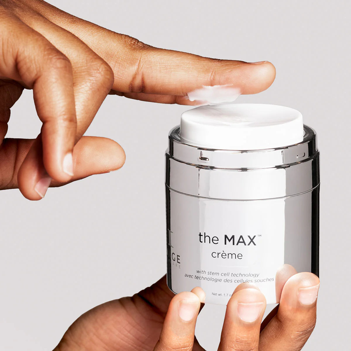 Close-up of hand applying the MAX™ crème, a peptide-powered moisturizer for youthful skin.