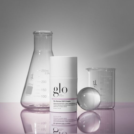 Bio-Renew EGF Cream by Glo Skin Beauty, shown with lab glassware for an age-defying skincare routine with vegan EGF, peptides, and retinol.