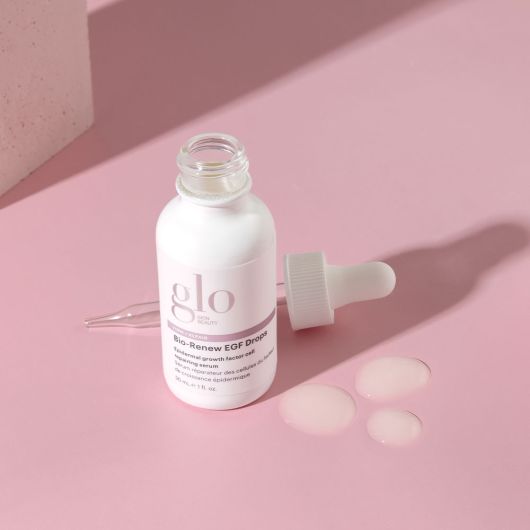 Bio-Renew EGF Drops serum bottle with dropper and skincare serum drops on a pink background.