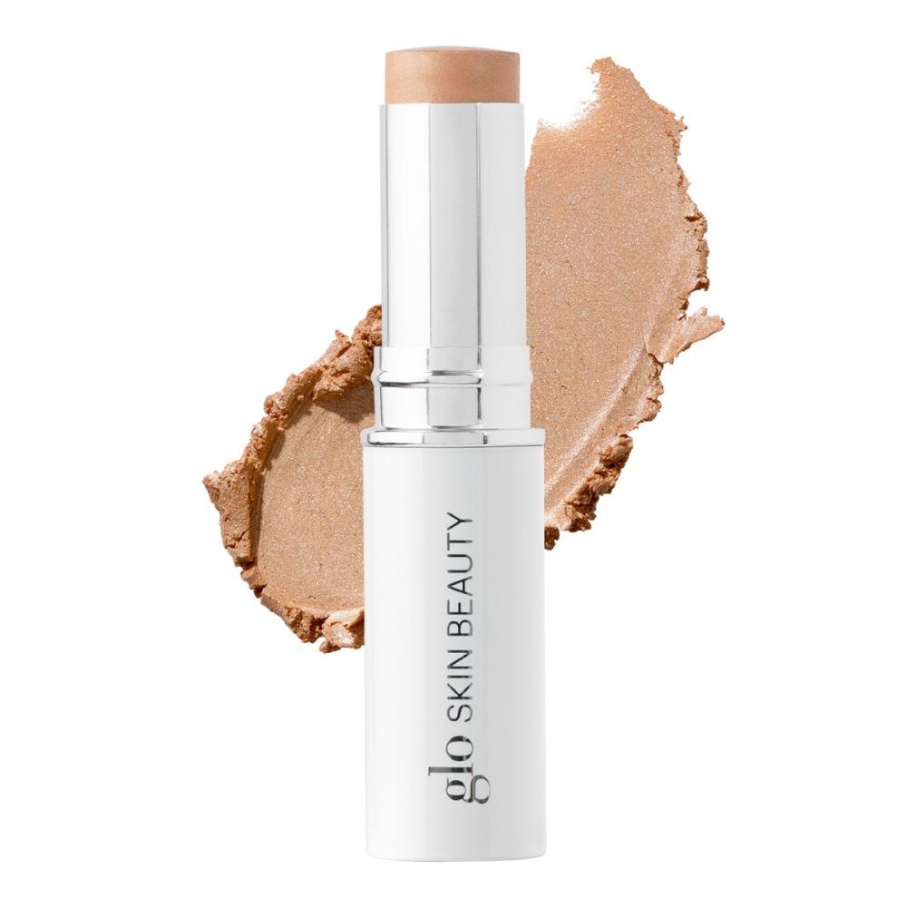 Glo Skin Beauty cream stick highlighter with a beige makeup smear background