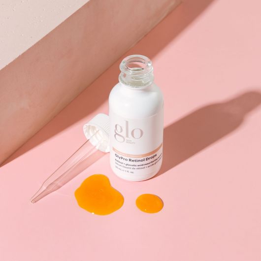 GlyPro Retinol Drops serum for retexturizing and renewing skin with retinol, glycolic acid, and gallic acid on a pink background.