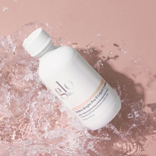 Hydra-Bright Pro 5 Liquid Exfoliant bottle with clear water splash showcasing a gentle and effective exfoliating treatment for smooth, bright skin.