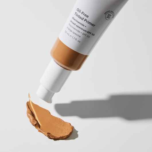 Oil-Free Tinted Primer SPF 30 bottle with a smear of sheer coverage, broad-spectrum sunscreen for even, smooth, and shine-free skin finish