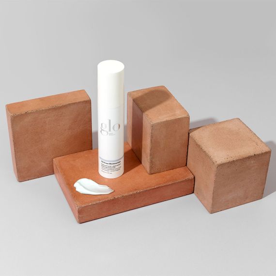 Oil Free Moisturizer bottle with a swatch of cream displayed on terracotta blocks, showcasing lightweight, non-clogging formulation.