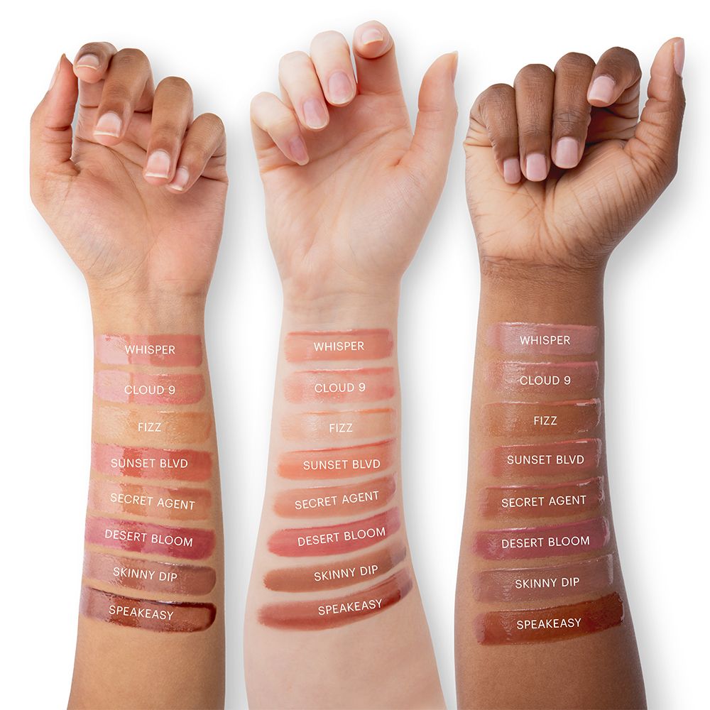 Swatches of various Conditioning Lip Gloss shades on three different skin tones showcasing the color range and high-shine finish.