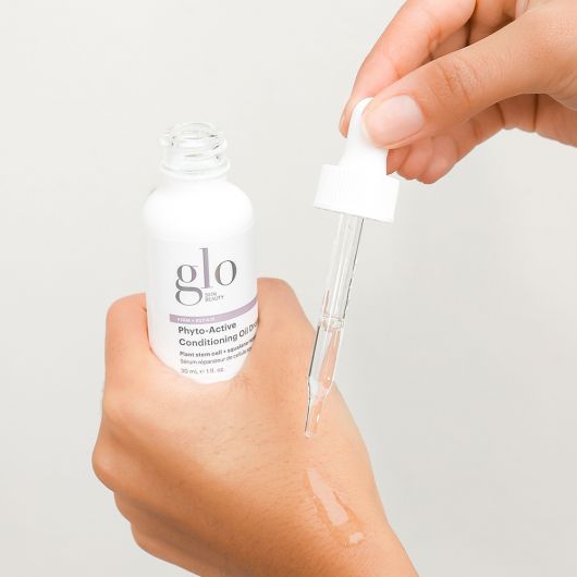 Applying glo Phyto-Active Conditioning Oil Drops for skin rejuvenation and anti-aging benefits