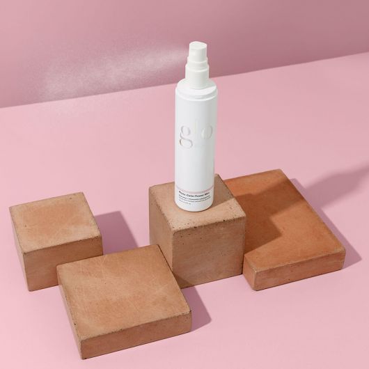 Phyto-Calm Flower Mist bottle on terracotta blocks against a pink background